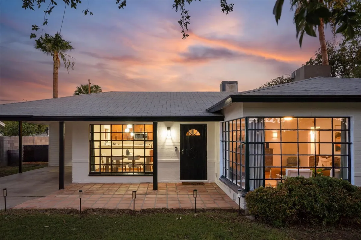 An exterior shot highlighting the front door, large windows, patio area, and landscaped garden. The space exudes a welcoming ambiance and showcases outdoor features that suggest tranquility and the ease of moving between indoor comfort and outdoor leisure. The well-maintained garden hints at resort-style living, supporting the premium, self-care narrative.